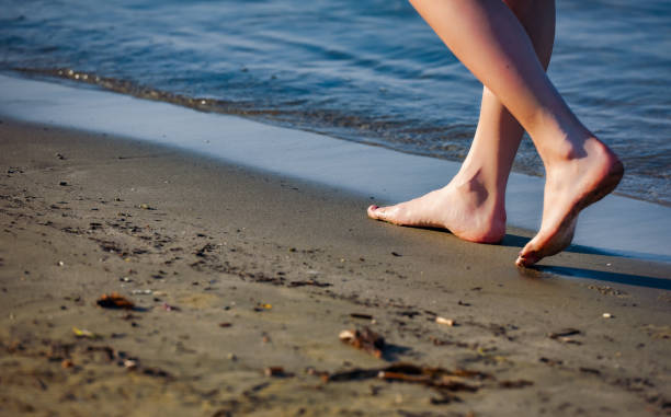 istock Foot path of woman that walks at beach during sunset 1287406375