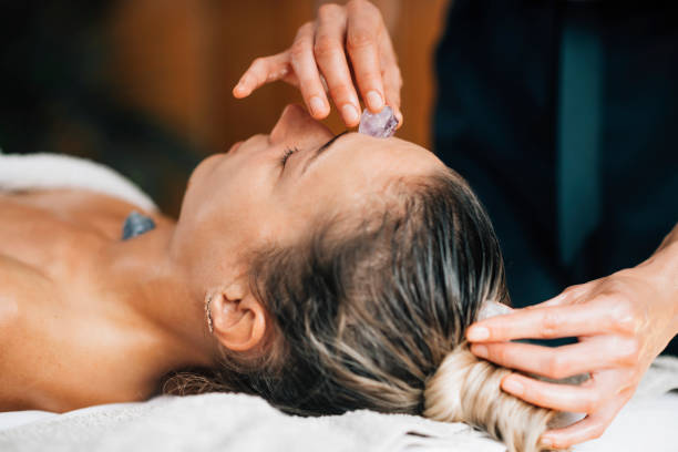 istock Ayurvedic Practitioner Using Gemstones and Crystals for Healing Female Patient Chakras 1287408857