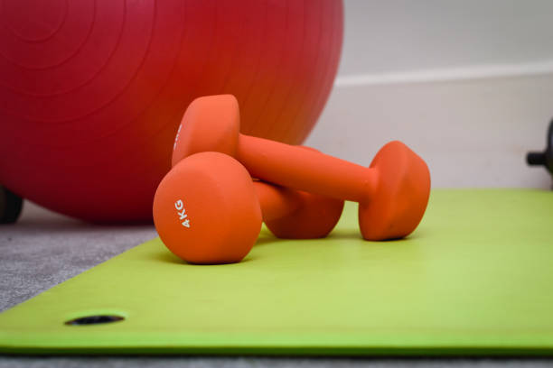 istock Fitness and weight training equipment with dumbbells and exercise mat 1287409882