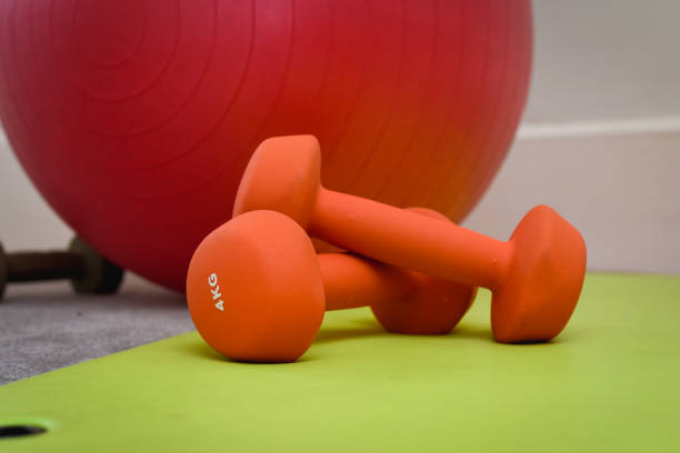 istock Fitness and weight training equipment with dumbbells and exercise mat 1287410071