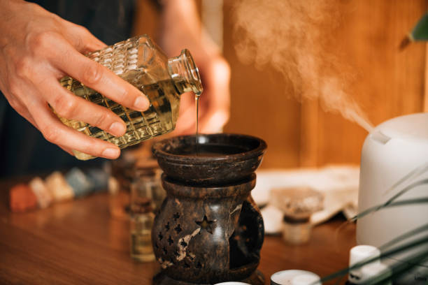 istock Ayurveda Aromatherapy Massage, Pouring Aromatic Oil in Essential Oil Diffuser 1287411816