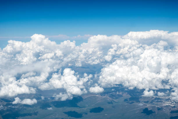 istock Aerial view of fluffy clouds over mountains, captured from plane. 1287414968