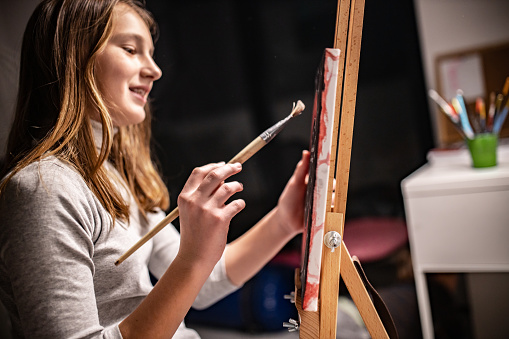 Talented Teenage girl painting at home and enjoying Art, education, creativity, teenage hobbies