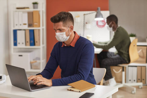 istock Mature Man Wearing Mask at Workplace 1287416642