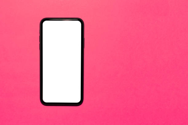 istock Top view close-up of modern smartphone with empty white mockup on screen. Isolated on background of pink color with copy space. 1287416848