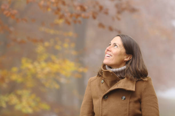 istock Happy middle age woman contemplating in a forest in fall 1287418971