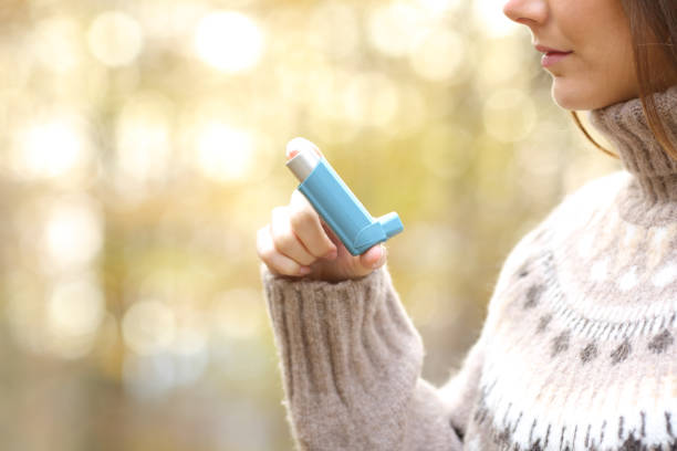 mujer mano sosteniendo inhalador de asma listo para usar en invierno - asthmatic fotografías e imágenes de stock