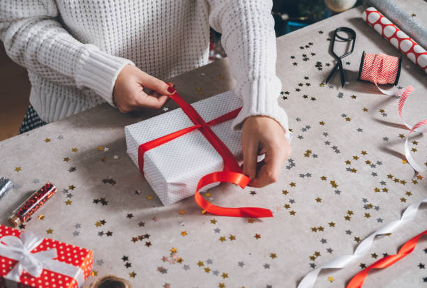istock Woman tying ribbon on Christmas present 1287419061