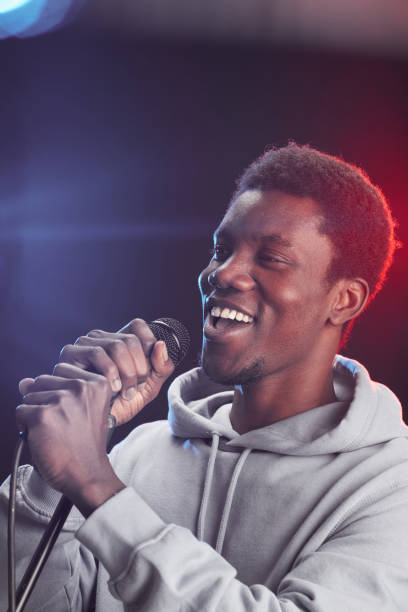 istock Young African-American Man Singing to Microphone 1287419320