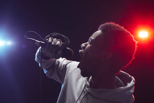 junger afroamerikanischer mann singt auf der bühne - music microphone singer stage stock-fotos und bilder