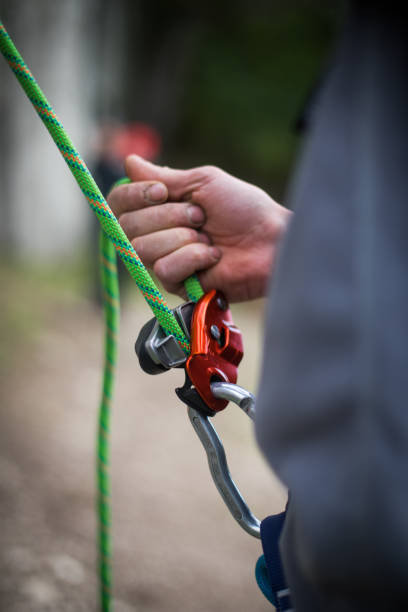 istock Man's hands operating a rock climbing belaying device 1287419388