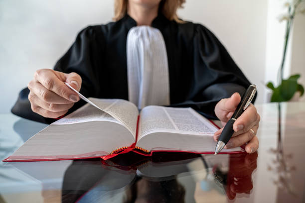 istock Justice, lawyer holding and reading open red law book 1287419859