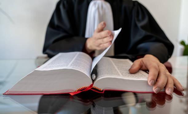 istock Justice, lawyer holding and reading open red law book 1287419942