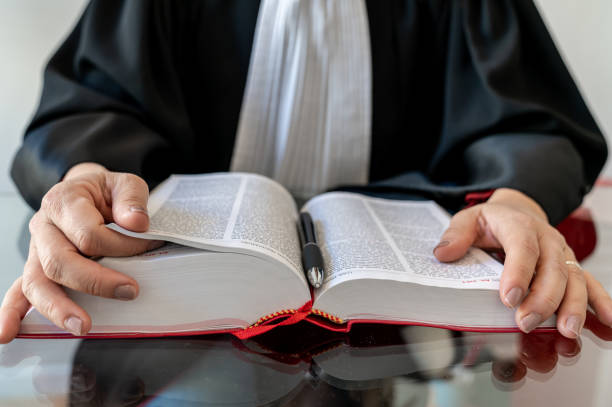 istock Justice, lawyer holding and reading open red law book 1287420267