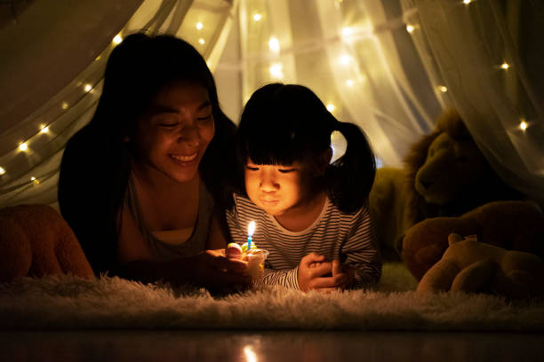 Happy birthday celebration. Happy birthday celebration, mom and young daughter. Blowing candle and make a wish in a tent. Happy birthday concept. birthday wishes for daughter stock pictures, royalty-free photos & images