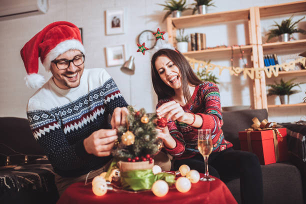 istock Happy couple decorating Christmas tree in their home 1287424135