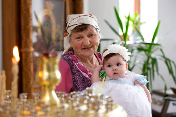 grandmother with her granddaughter by the church candles. - great grandchild imagens e fotografias de stock