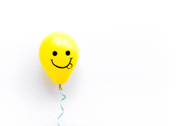 Fluffy smiling emoji face icon on pink and soft balloon surface.