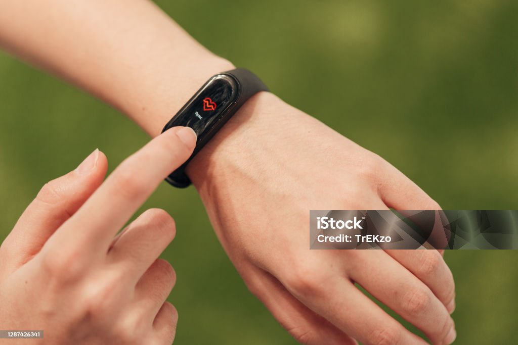 Girl Checking Her Heart Rate On Smart Watch After Gymnastic Exercises The smartwatch on the wrist measures the heartbeat. Pulse check. Fitness Tracker Stock Photo
