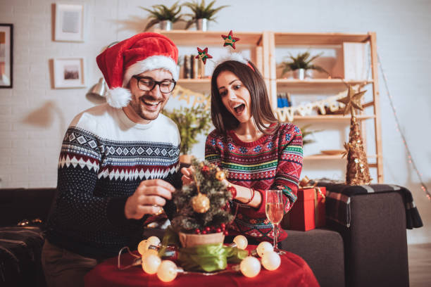 istock Happy couple decorating Christmas tree in their home 1287426778