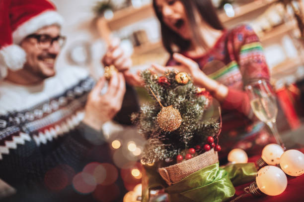 istock Happy couple decorating Christmas tree in their home 1287427697