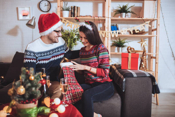 istock Young couple celebrating Christmas at home opens gift 1287427704