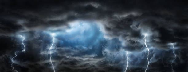 istock Sun rays in the gap between the clouds and sparkling lightning in the dark sky. 1287429650