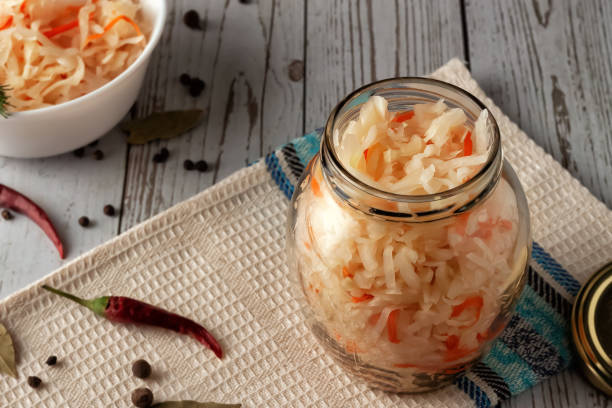 istock Sauerkraut with carrots and spices in a jar. Horizontal top view, rustic style 1287430356
