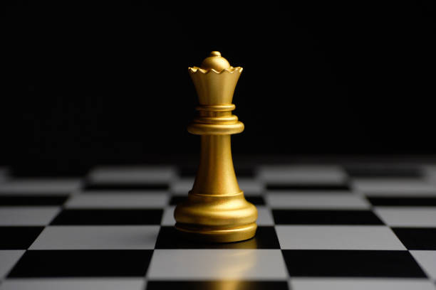 istock Gilded chess piece queen on the board 1287431918