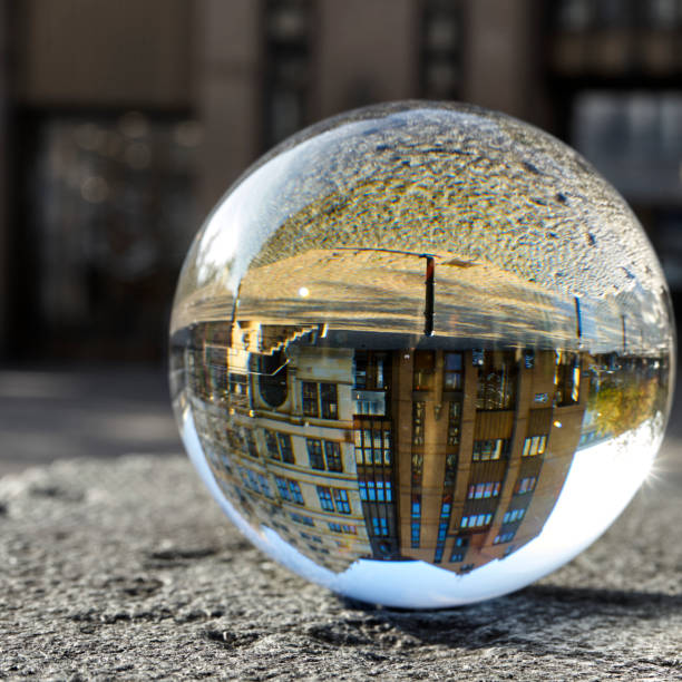 istock Crystal ball on a rough stone slab with the inverted spherically distorted image of a building in the city center 1287432656