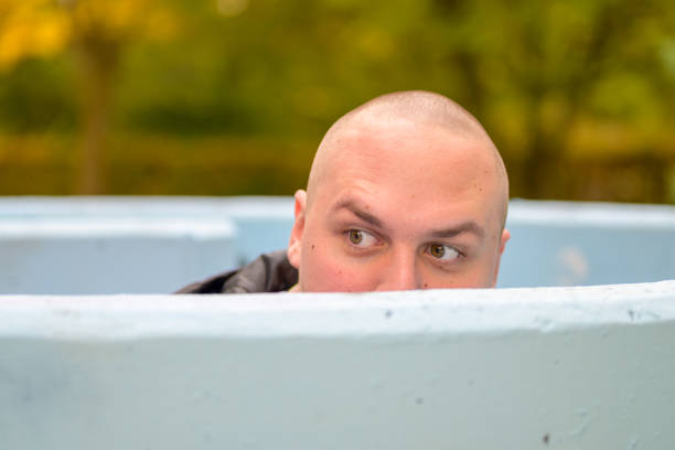 istock Man peering over a tank with intrigued expression 1287432692