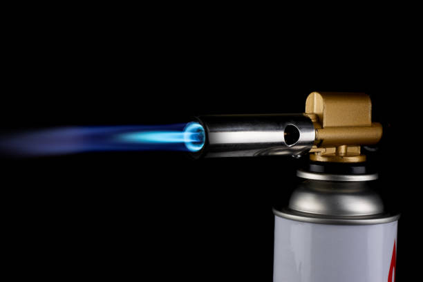 istock Flamethrower burner gas blow torch Ignition with blue fire flame at black background 1287432893