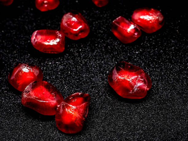 istock red grains of ripe pomegranate on a black background, macro 1287435025