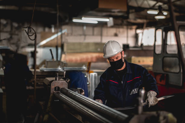 istock Hardworking man in factory workshop working during epidemic 1287435960
