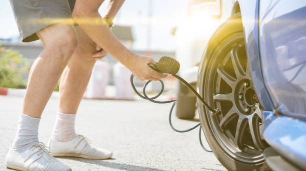 istock person pump up the car wheels tires with a compressor with manometer 1287436765