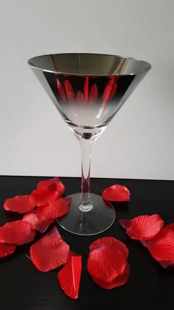 Silver cocktailglass and red rose petals