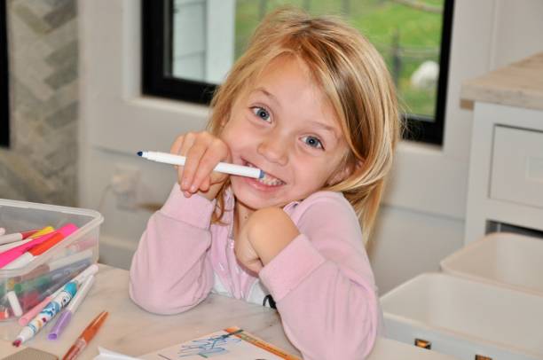 istock Young Girl doing homework at kitchen counter 1287437231