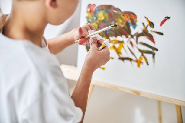 istock Artist standing before the easel in her home studio 1287439251