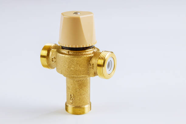 Plumbing connection with close up water brass thermostatic mixing valve isolated on white background.