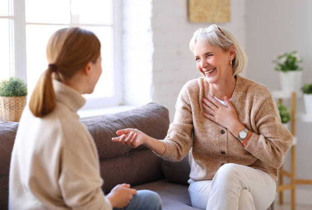 istock Happy women chatting on sofa at home 1287440076