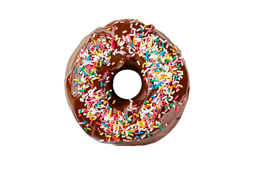 A donut covered with chocolate frosting and decorated with colored sprinkles isolated on a white background. Delicious colorful chocolate doughnut