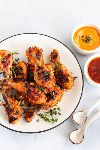 grilled chicken drumsticks on a plate with condiments directly above vertical photo - 7003 imagens e fotografias de stock