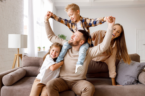 Glad caucasian different women hugging, have fun, enjoy love and spare time, sit on floor on white wall background. Family relationships, grandmother, mom and daughter, full length