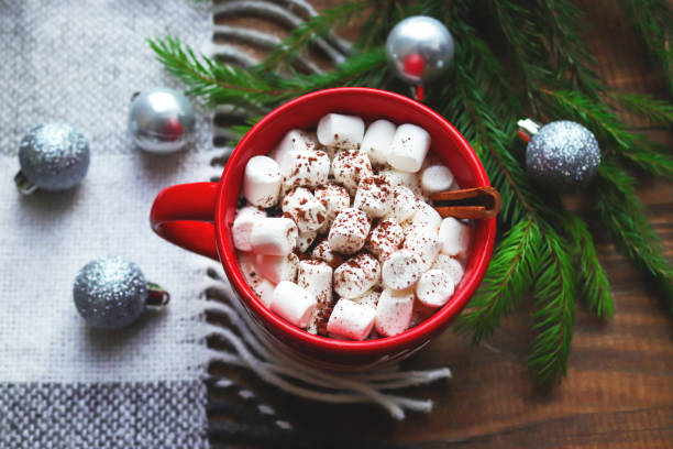 heiße schokolade in einem roten becher mit marshmallows und zimt auf holzhintergrund mit karierten, weihnachtskugeln und tannenzweigen. gemütliches winterkonzept. nahaufnahme, selektiver fokus, flach liegend, ansicht von oben - comfort food high angle view directly above close up stock-fotos und bilder