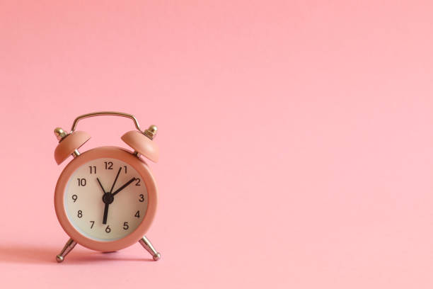 istock Pink alarm clock on pink background with copy space for text. Morning concept 1287444861