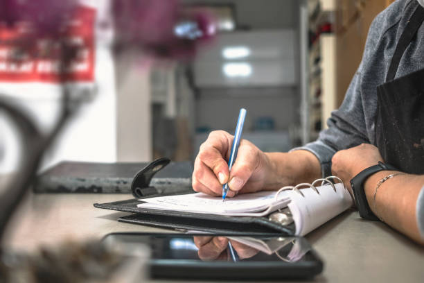 istock Restaurant owner senior woman taking notes 1287445107
