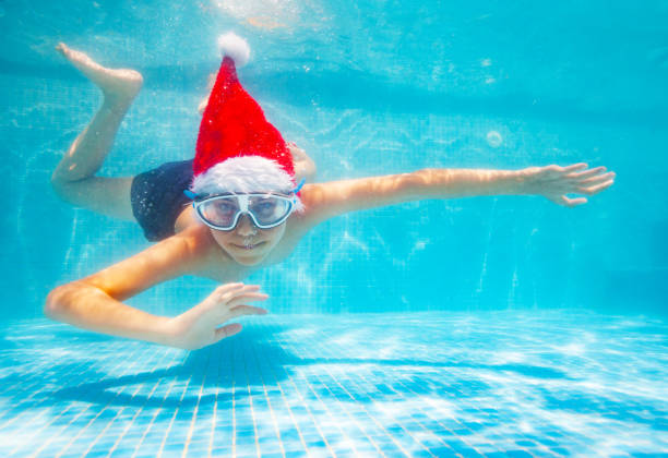istock Boy dive underwater wearing Santa Claus ha 1287445197