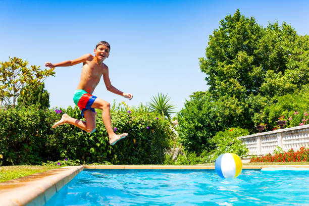 istock Little boy jump in water diving after long run 1287445198