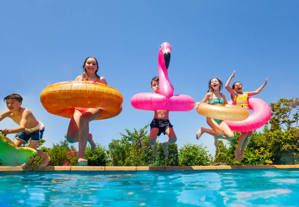 istock Kids with doughnut and flamingo dive to the pool 1287445215
