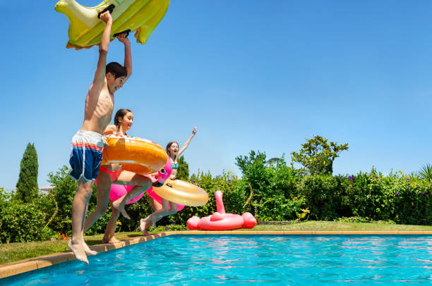 istock Kids hold inflatable toys dive into the water pool 1287445228